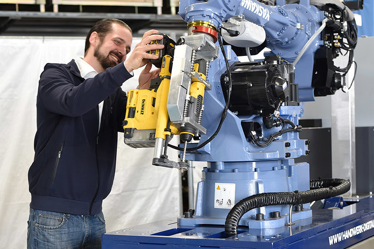 Fahrbarer Roboter im Bildungszentrum Schweinfurt wird von einem jungen Mann begutachtet