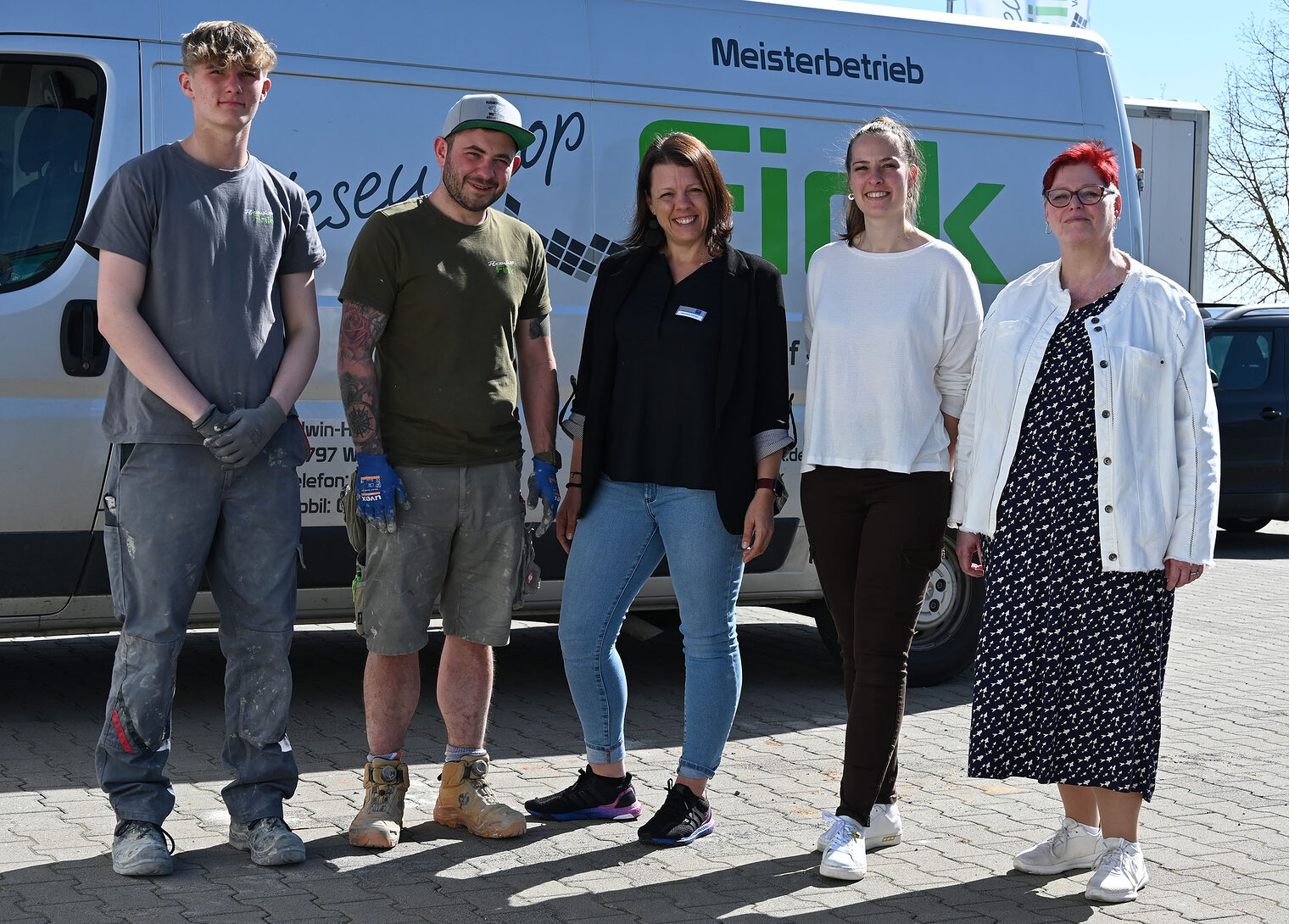 Gruppenfoto mit fünf Personen auf Firmengelände