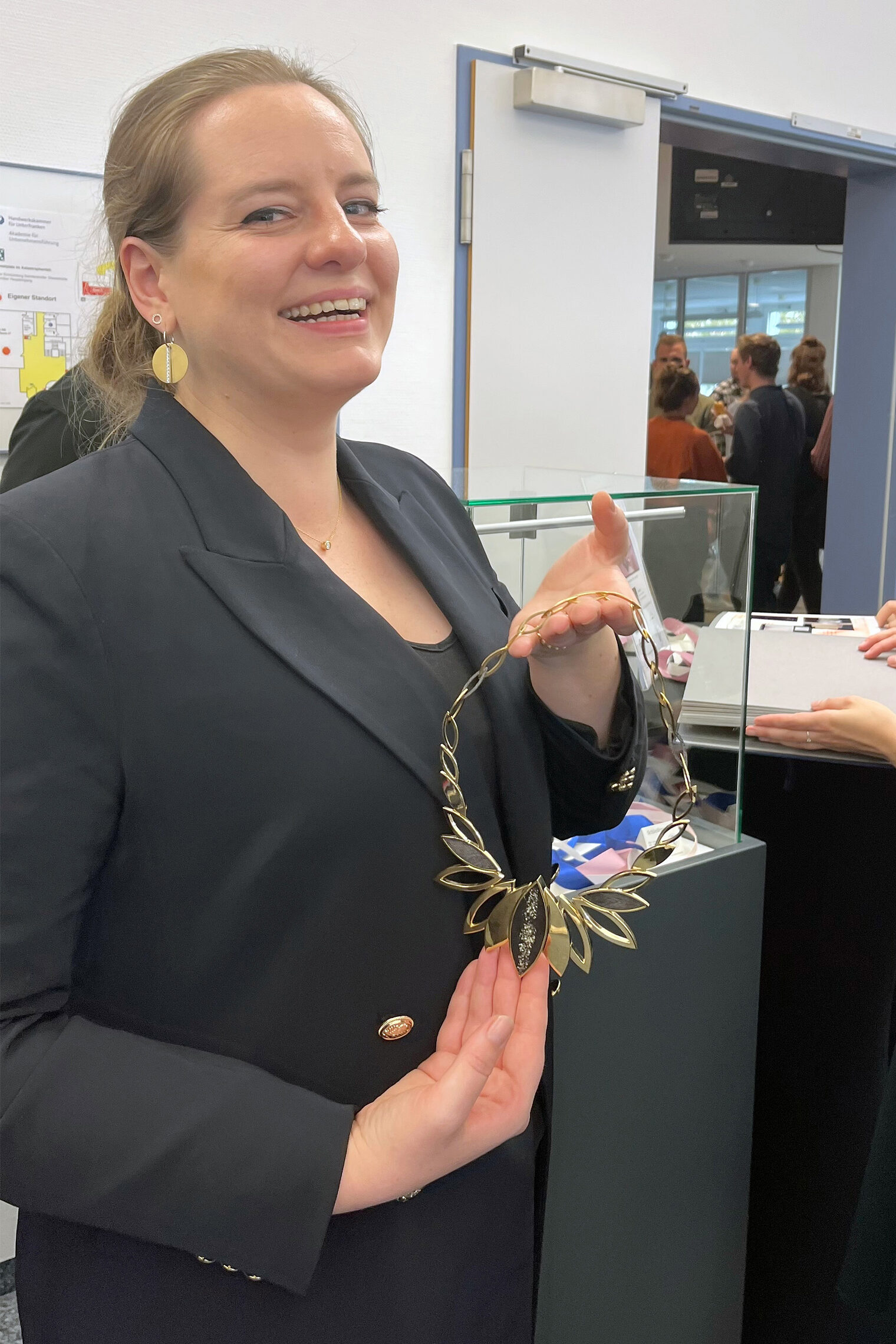 Ausstellung der Schreiner + Gold- und Silberschmiedemeisterstücke 2023 Meisterschülerin mit Goldschmiedemeisterstück - eine blätterförmige Kette