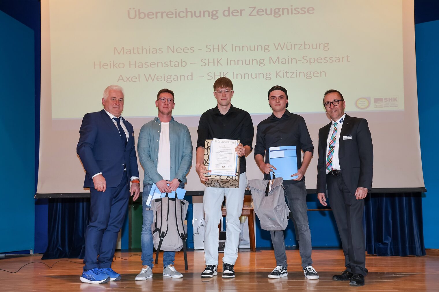 Auszeichnung der drei Prüfungsbesten Gesellen der SHK-Innung Würzburg mit Urkunden auf der Bühne