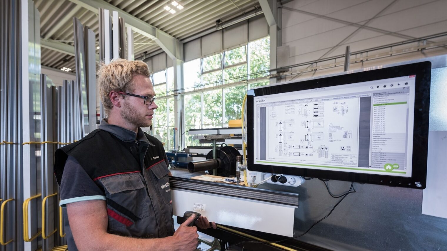 Ein Mann steht vor einem großen Bildschirm und prüft ein Gerät