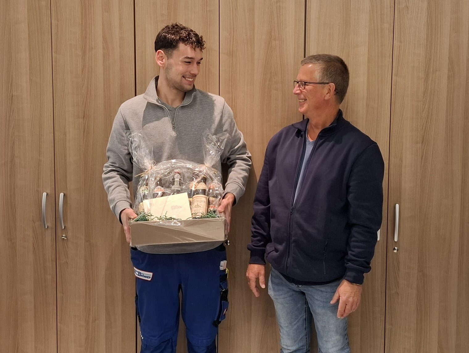 DMH 2025 | Kammersieger Sieger und Betriebsinhaber mit Geschenkkorb vor Wand