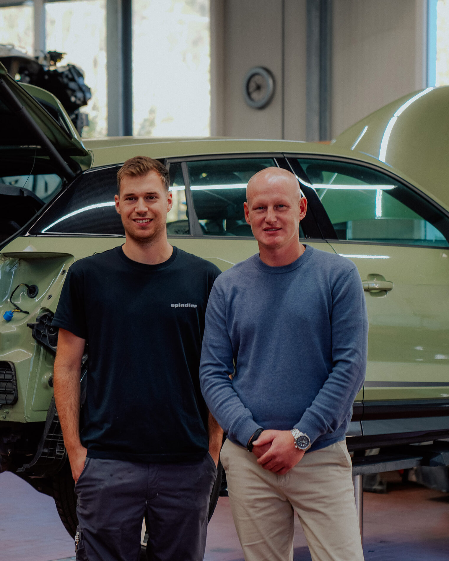 DMH 2025 | Kammersieger Geselle und Ausbilder vor Karosserie schauen in Kamera