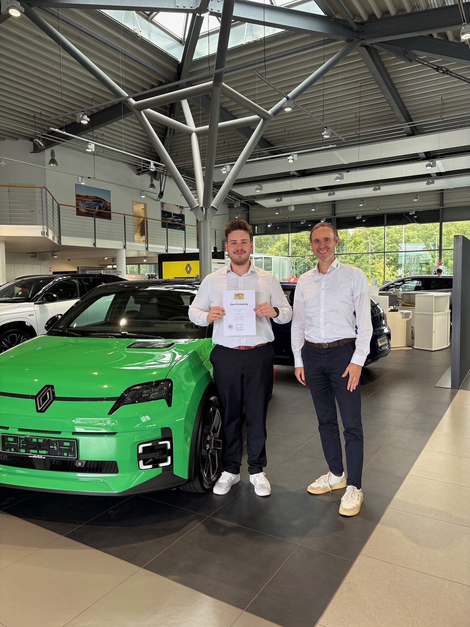 Zwei Männer im Autohaus Zwei Männer stehen im Autohaus vor einem grünen Wagen