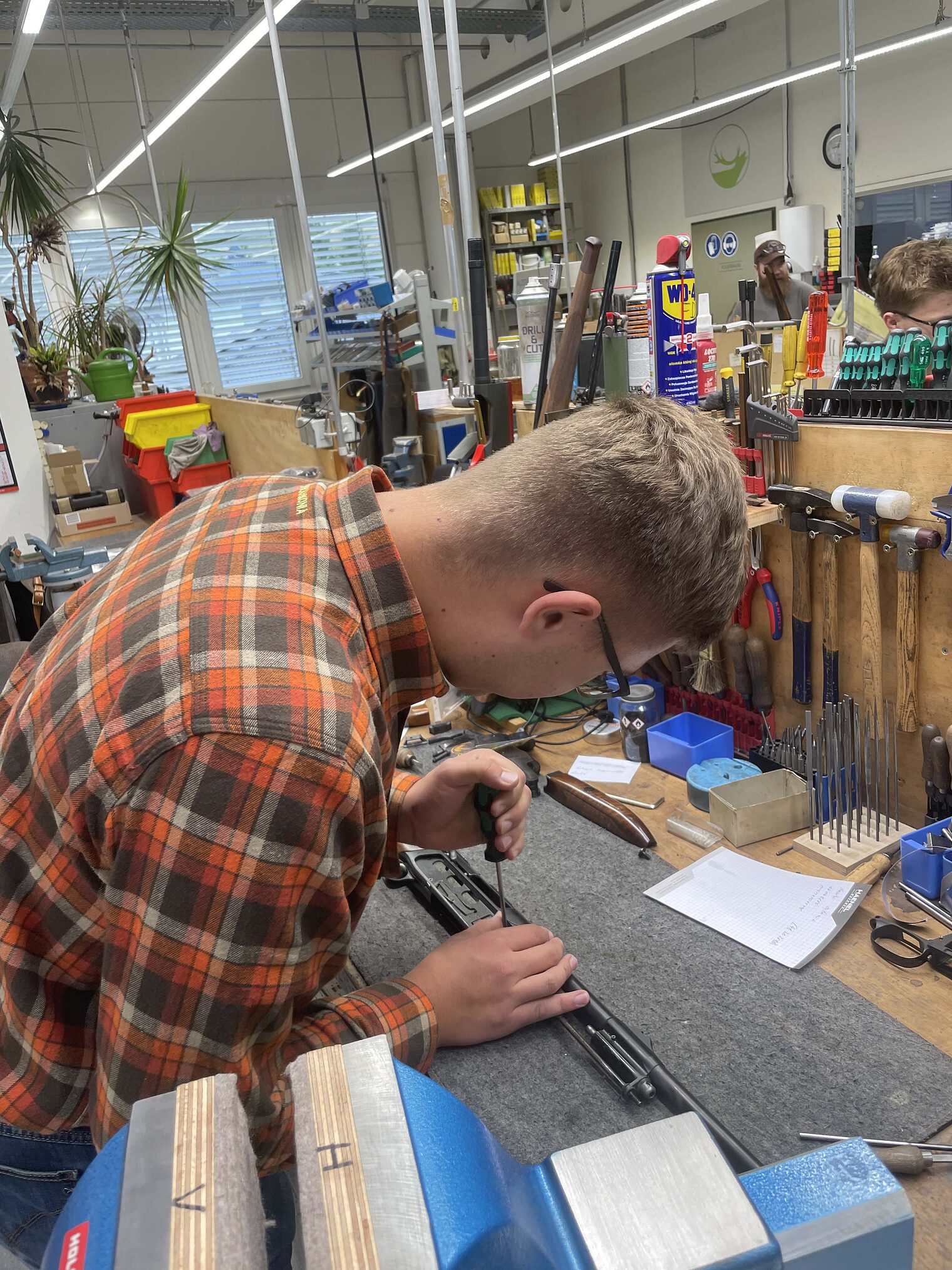 Büchsenmacher Zwei Männer stehen in der Werkstatt