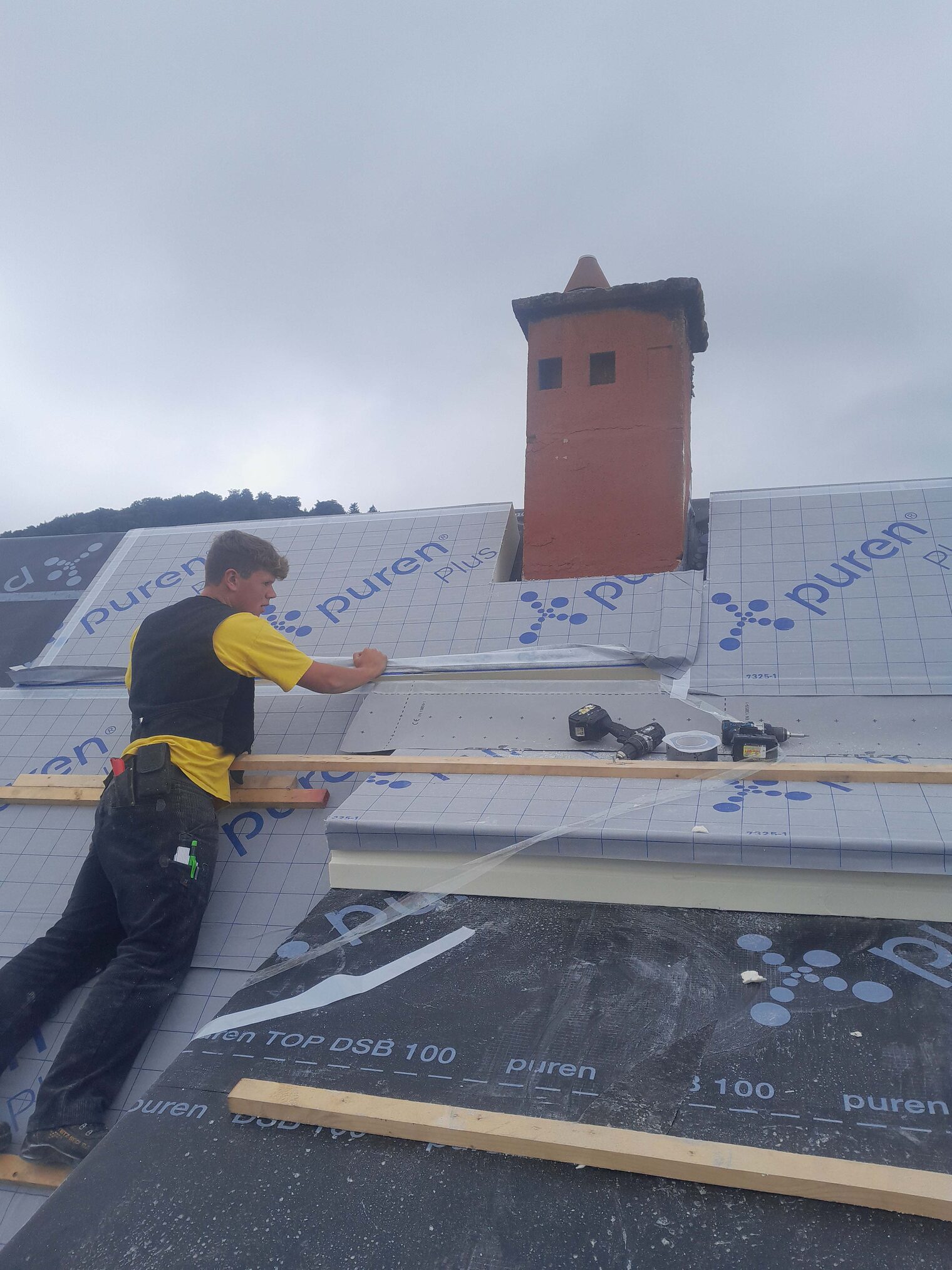 Dachdecker Dachdecker steht auf einem Dach und repariert ein Dach