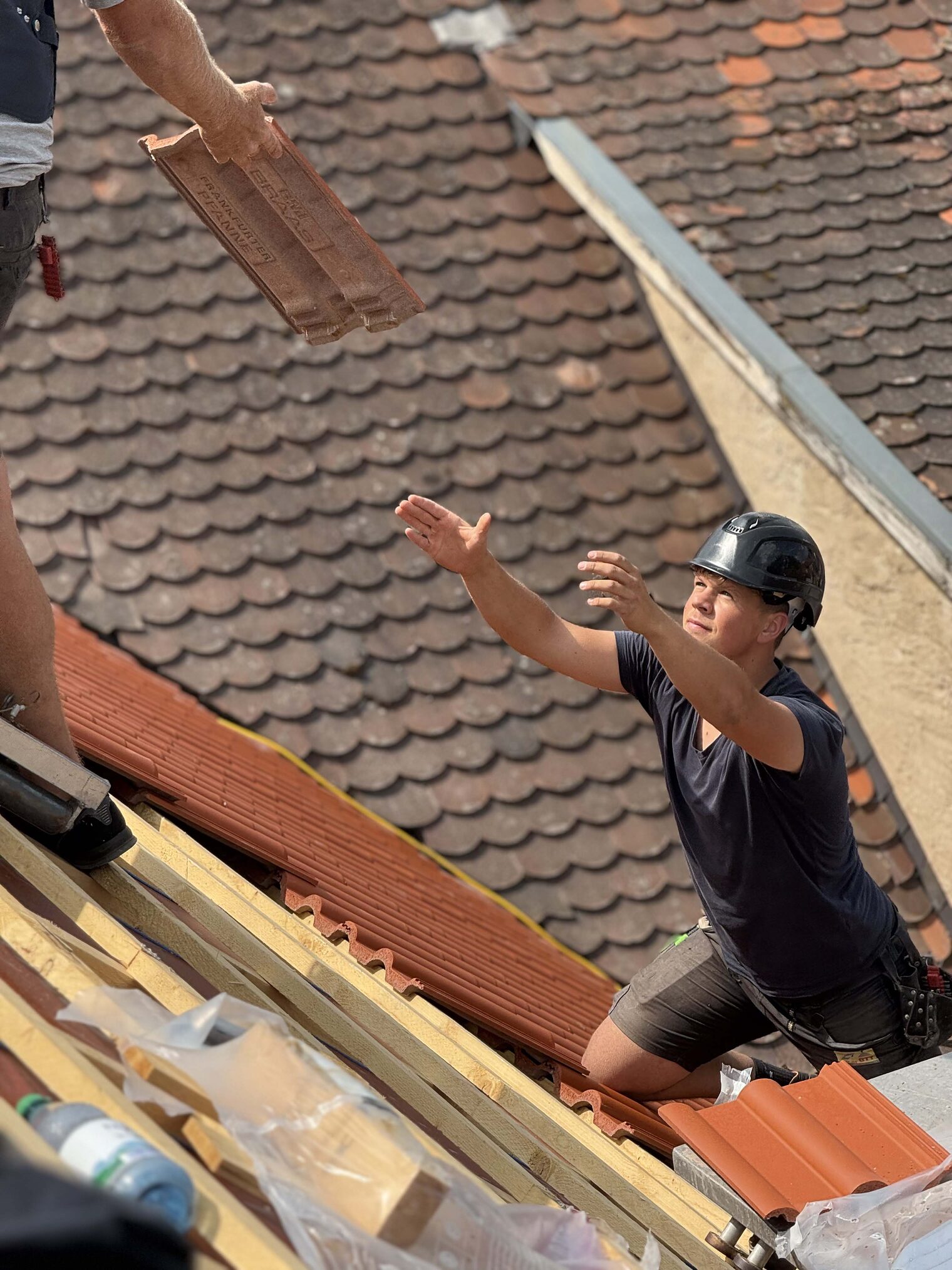 Dachdecker Dachdecker steht auf einem Haus und fängt Material