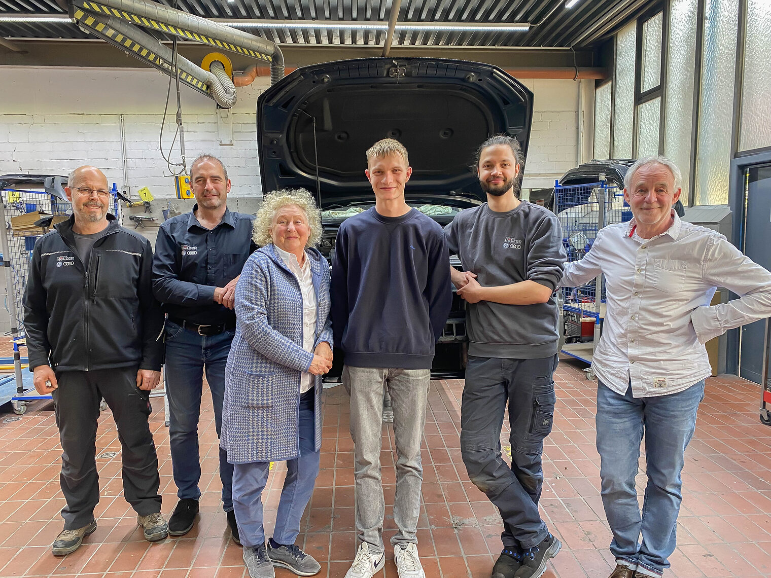 Gruppenbild von 6 Menschen im Stehen in KFZ-Werkstatt Gruppenbild von 6 Menschen im Stehen in KFZ-Werkstatt, in der Mitte der Kammersieger