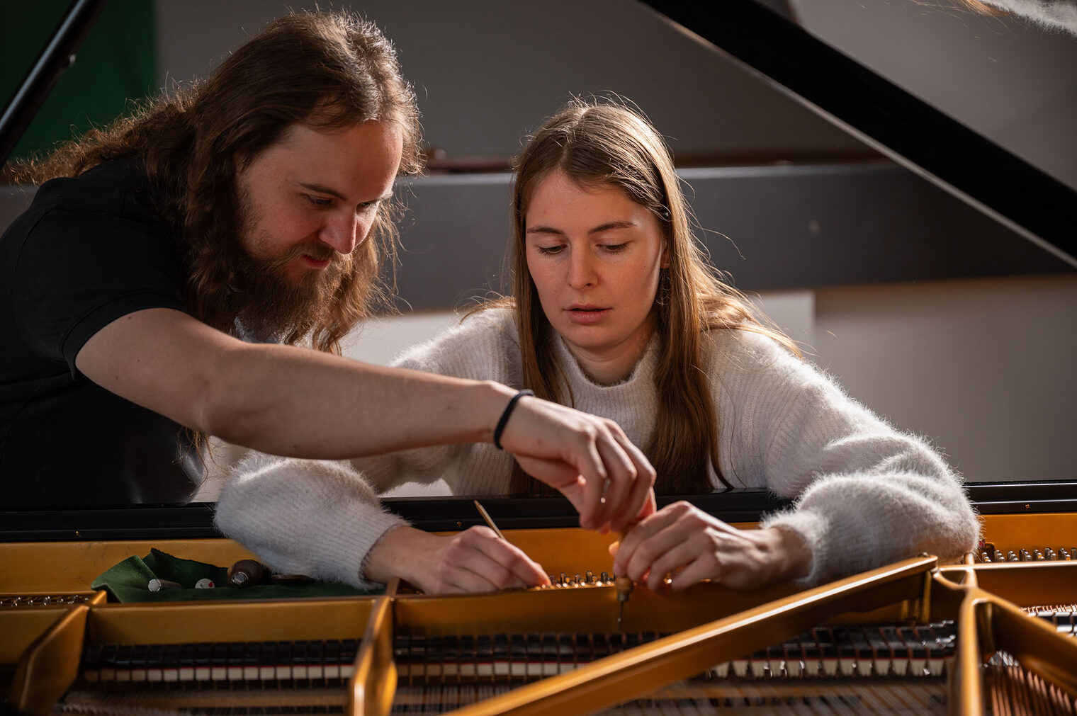 Mann und junge Frau schauen in einen offenen Flügel Mann und junge Frau schauen in einen offenen Flügel