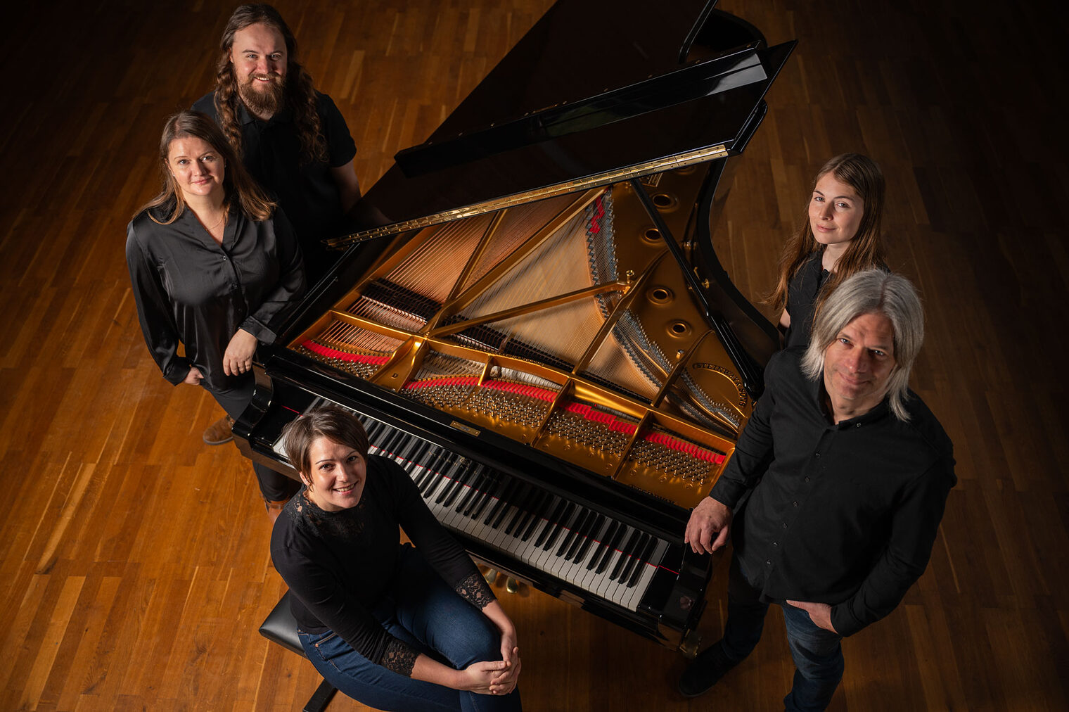 Gruppenbild: 5 Menschen um einen offenen Flügel, aus Vogelperspektive Gruppenbild: 5 Menschen um einen offenen Flügel, aus Vogelperspektive