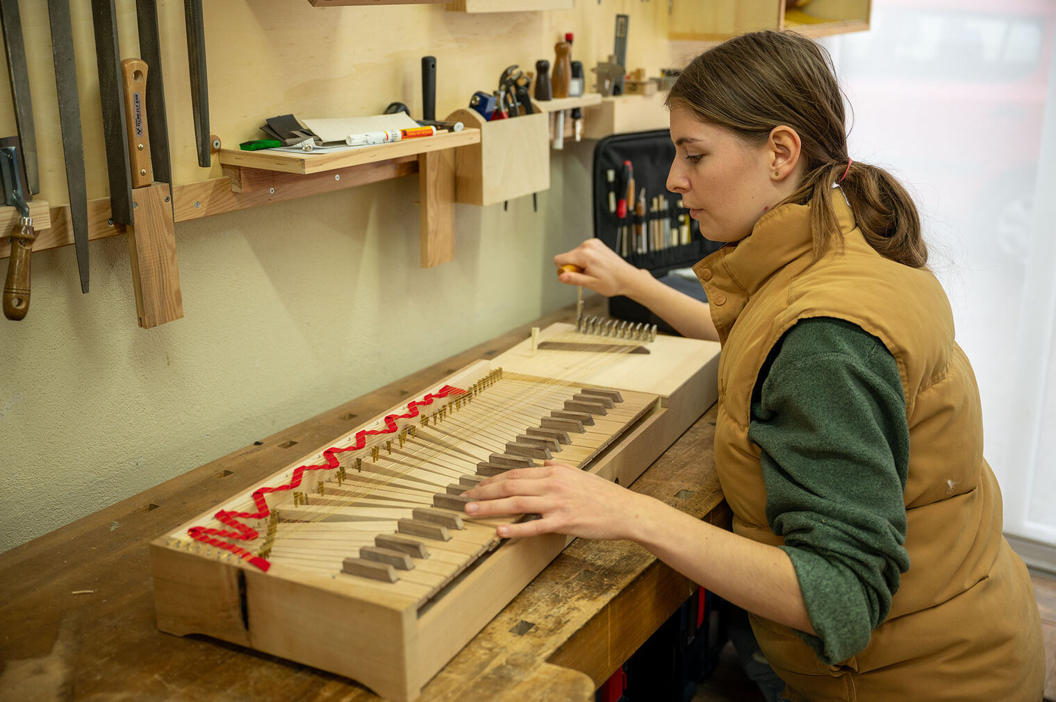 Junge Frau an Tasteninstrument aus Holz Junge Frau an Tasteninstrument aus Holz