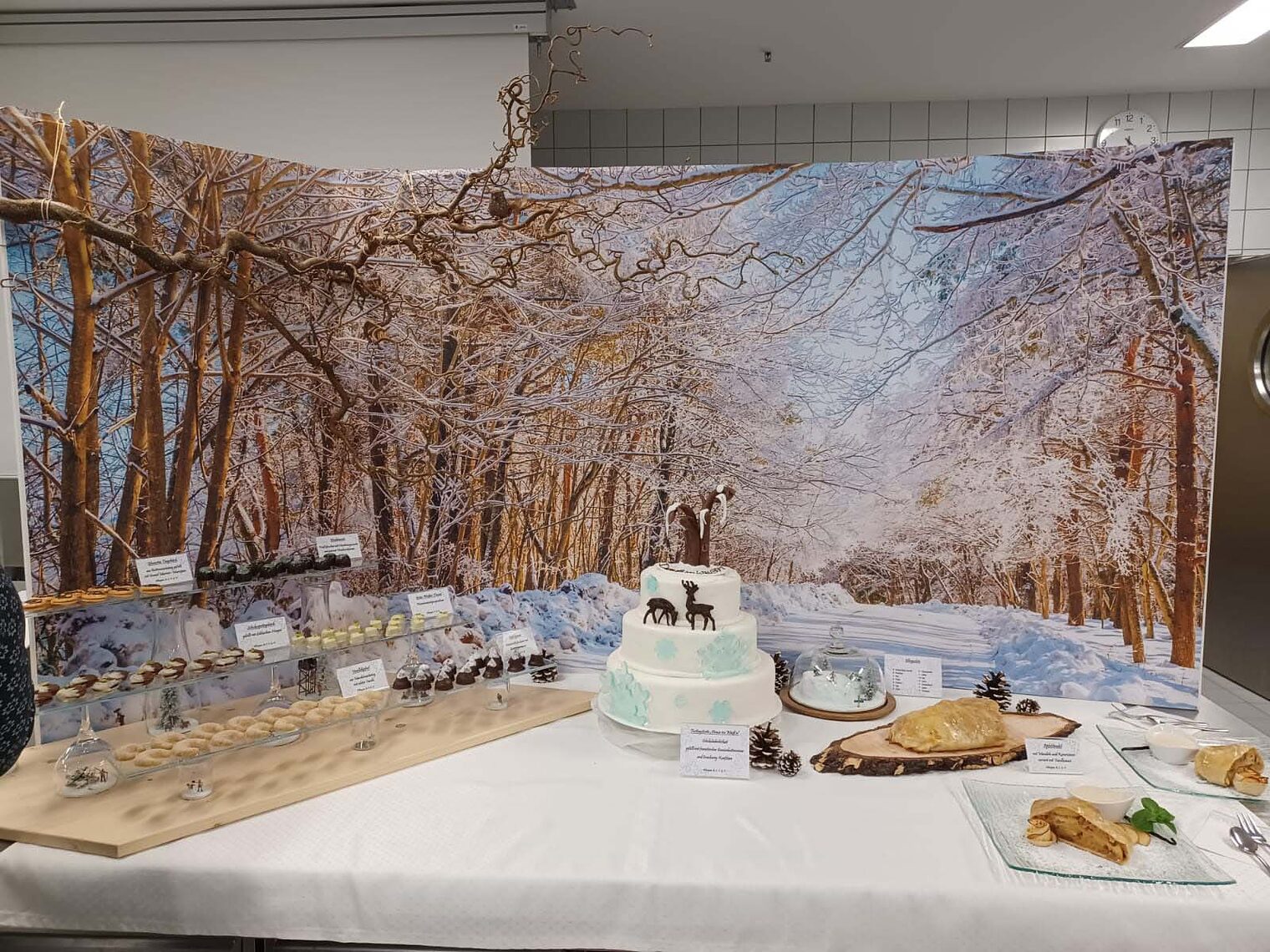 Aufbau von Gebäck auf einem Tisch vor winterlichem Hintergrund Aufbau von Torten und Gebäck auf einem Tisch vor winterlichem Hintergrund