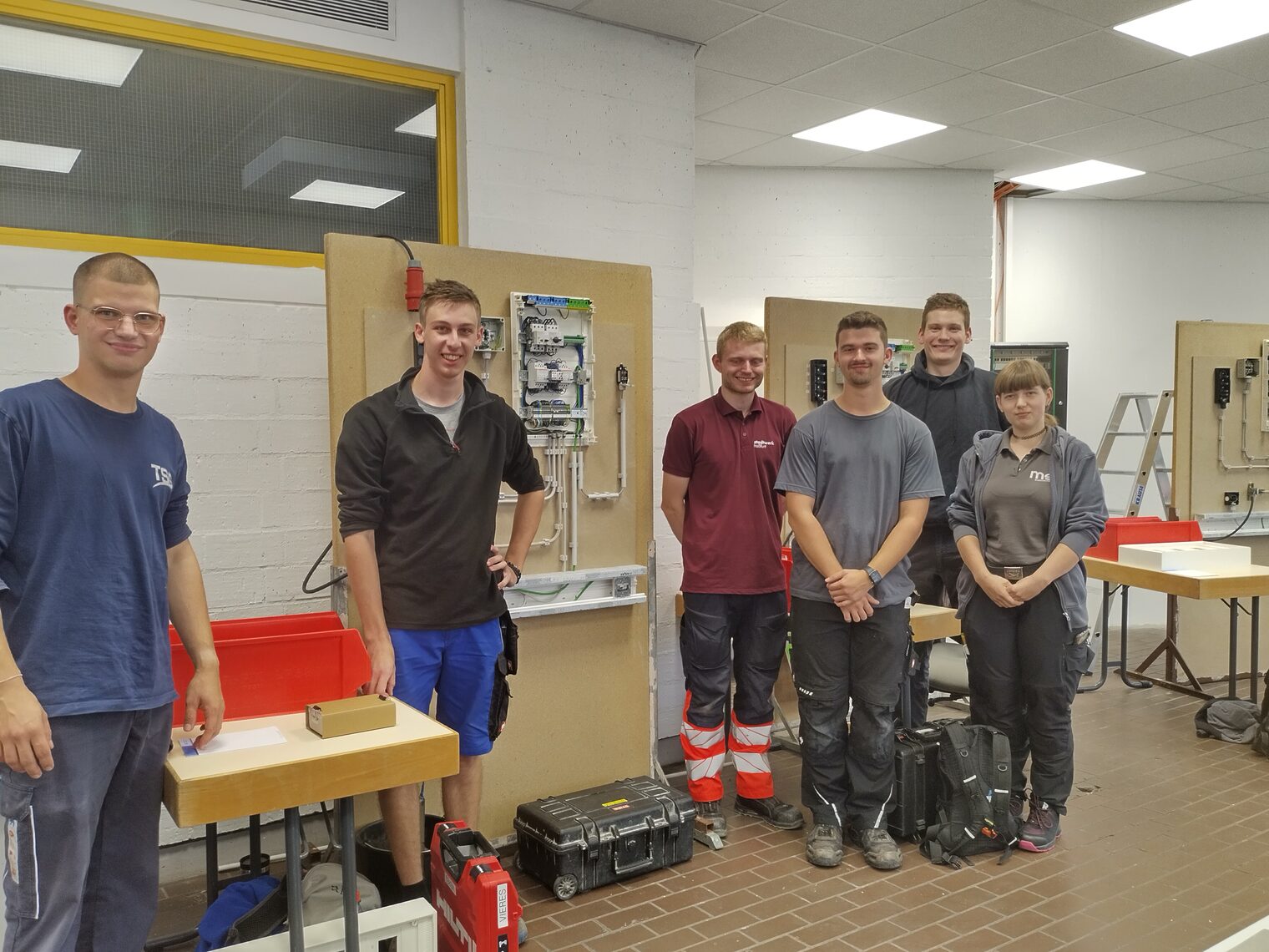 Gruppenbild: 5 Elektroniker, 1 Elektronikerin in Arbeitskleidung Gruppenbild: 5 Elektroniker, 1 Elektronikerin in Arbeitskleidung