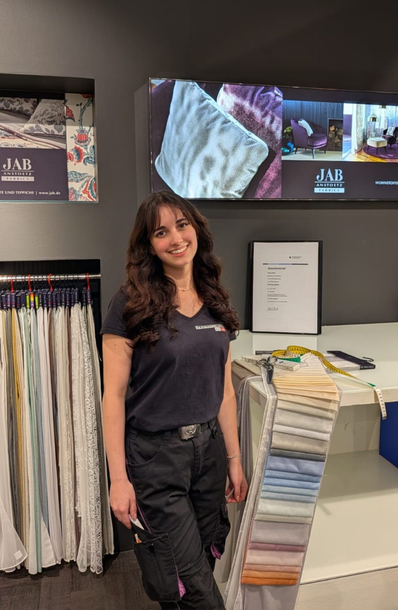 DMH 2025 | Kammersieger Raumaussatterin steht im Geschäft zwischen Stoffproben